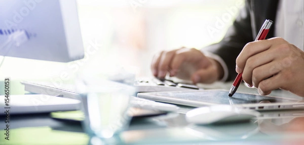 Fototapeta Biznesmen oblicza za pomocą tabletu i kalkulatora