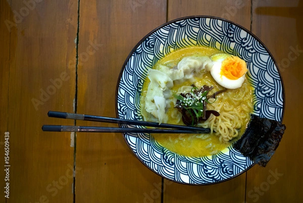 Fototapeta A bowl of ramen noodle, Japanese food with chopstick on a wooden table