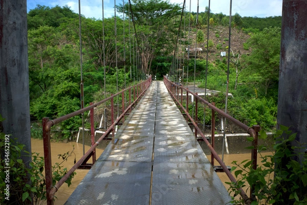Fototapeta A narrow old hanging bridge in the forest in Gunung Kidul, Yogyakarta, Indonesia