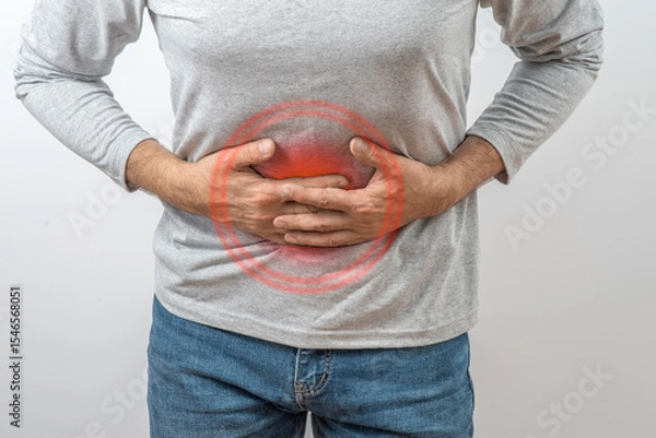 Fototapeta Mature man clutching his stomach. Symptoms of inflammation and pain in the intestines, liver, and stomach in an adult man.
