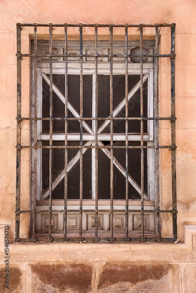 Fototapeta Stone facade with window with wrought iron lattice in Spain