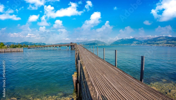 Fototapeta The longest wooden bridge in Switzerland, Holzbrücke Rapperswil-Hurden, spanning the narrowest and shallowest part of Lake Zurich.