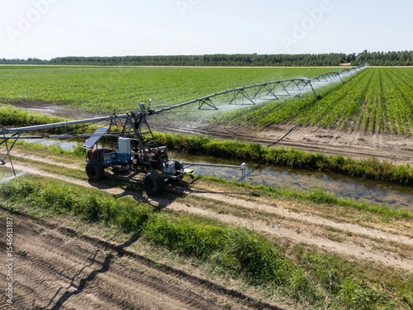 Fototapeta Autonomous machine is moving watering pivot along irrigation canal