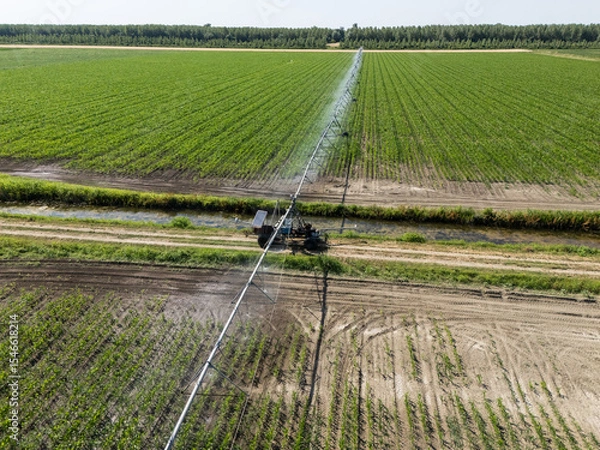 Fototapeta Autonomous machine is moving watering pivot along irrigation canal