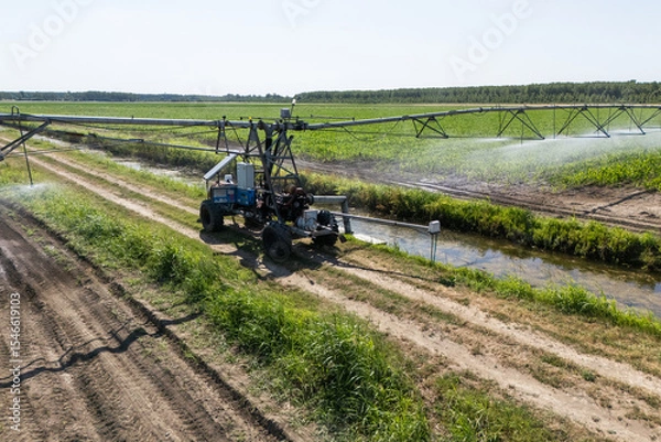 Fototapeta Autonomous machine is moving watering pivot along irrigation canal