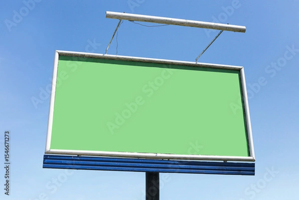 Fototapeta Empty billboard with green screen. Blank advertising banner on metal frame. Outdoor mockup display for marketing. Sky background with clouds. Copy space for design. Urban commercial message area.
