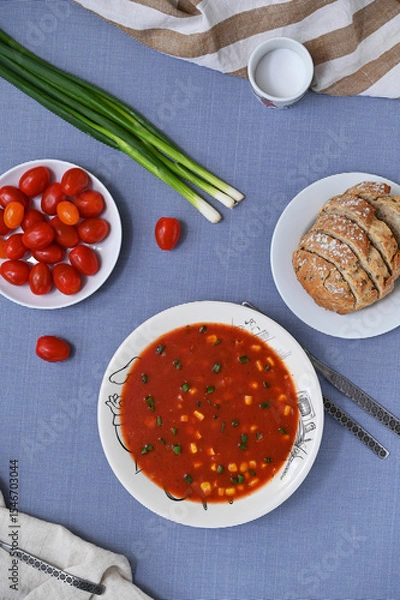Fototapeta tomato soup with sweet corn and green onions on the table