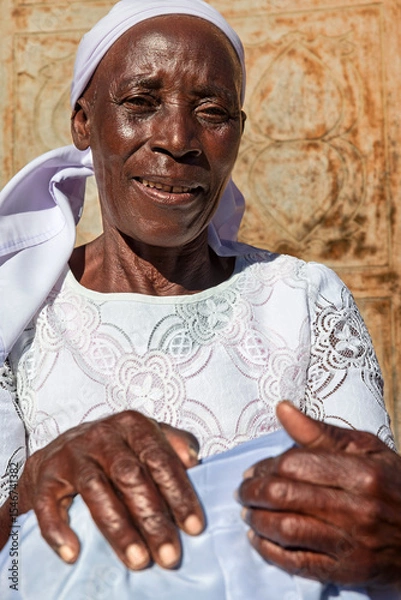 Fototapeta village single zezuru old african woman wearing a headscarf sited in front of the house , in the yard, close portrait