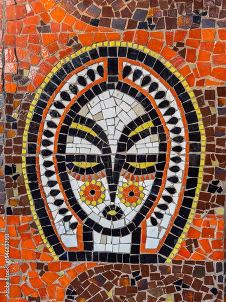 Obraz Colorful mosaic of a stylized ethnic face.Abstract mosaic wall art decoration.Close-up detail of a public art mosaic panel.Ancient-style ornamental face created with the trencadis mosaic technique