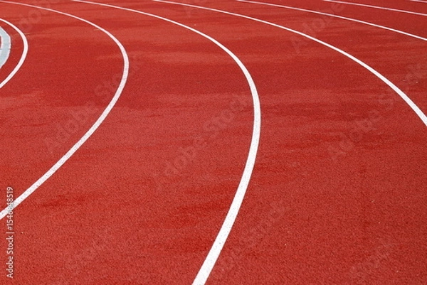 Fototapeta Red artificial running track with white round dividing lines, treadmill rubber texture, sports, athletics