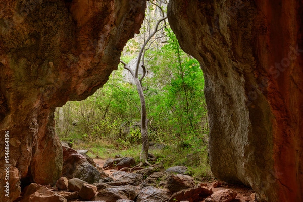 Fototapeta View of the Chillagoe - Mungana Caves National Park, featuring towering limestone fins and jagged spires framed by blue sky, with dry bushland and red earth in the surrounding landscape