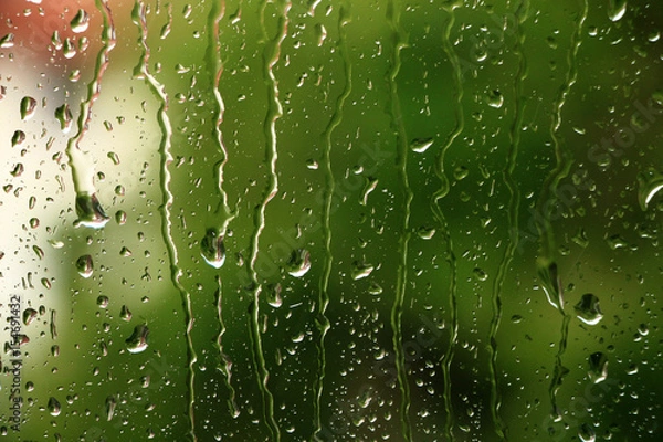 Fototapeta Rain drops on window with green in background