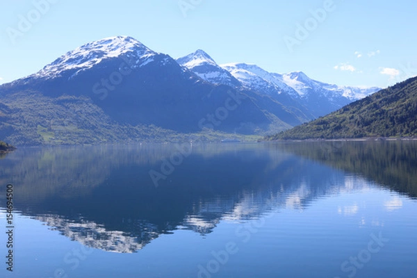 Fototapeta A wonderful beautiful spring day in Loen in Sogn with green trees and snowy mountains.