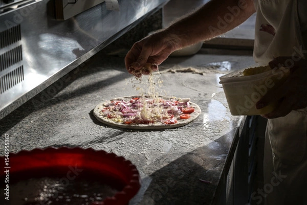 Obraz preparazione di una pizza sul bancone di una pizzeria