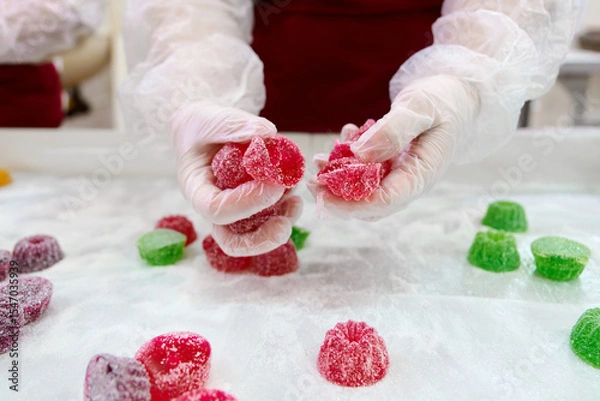 Fototapeta Hands holding colorful marmalade confections in a candy shop during a crafting session