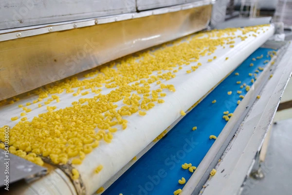 Fototapeta Pasta gracefully gliding along a conveyor belt in a bustling factory environment, showcasing modern food production techniques