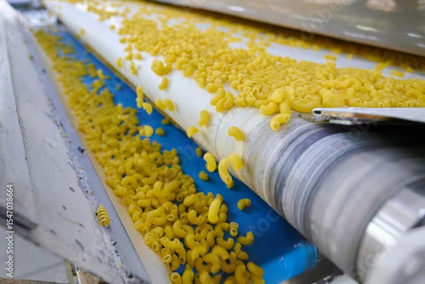 Fototapeta Fresh pasta gliding on a conveyor belt in a bustling factory setting during the daytime