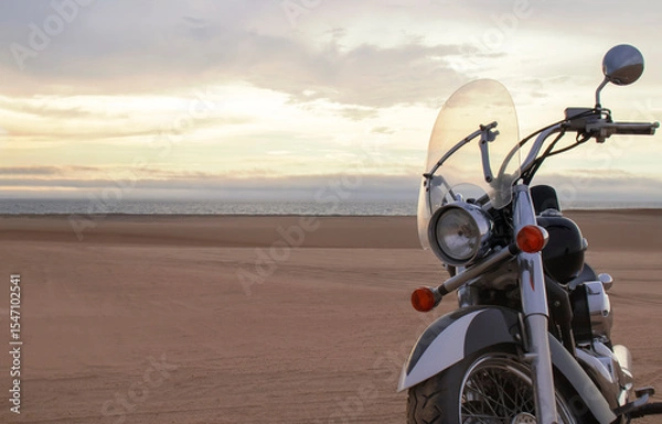 Fototapeta Off-road motorcycle standing still in the open desert beneath heavy clouds. A strong visual of freedom, rugged adventure, and the thrill of riding through wild, untamed terrain.