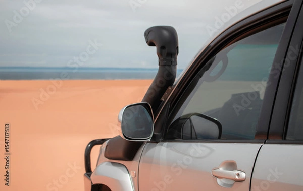 Fototapeta A powerful gray 4x4 SUV captured close-up in endless sands, ready for exploration and long desert expeditions.