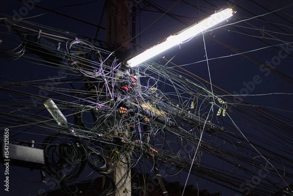 Obraz Chaos of cables and wires on an electric pole. Many electrical cable - wire and telephone line on electricity post, Thailand,