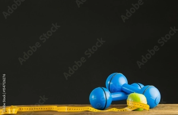 Obraz Blue dumbbells with green apple and measuring tape