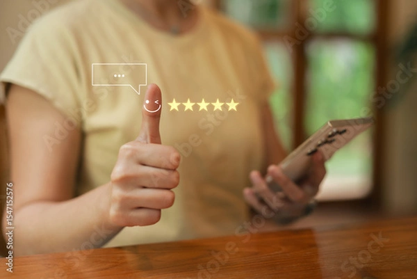 Obraz Asia woman using smartphone for select smiley face icon for client evaluation and customer satisfaction after use product and service concept...