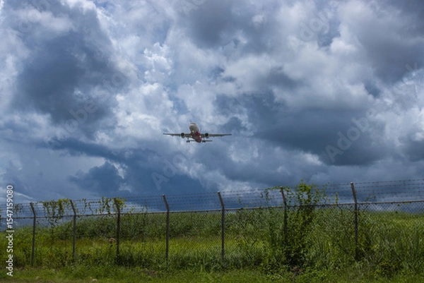 Fototapeta the security area of the airport and the plane flying in for landing