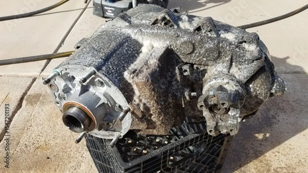 Fototapeta Cleaning a Transfer Case from a 1980s 4x4 SUV Sits on a Driveway 
