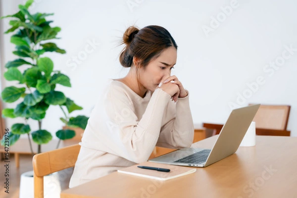 Fototapeta Thoughtful tired woman working on laptop computer looking on screen thinking solving problem at home office, serious woman search for inspiration make decision feel lack of ideas