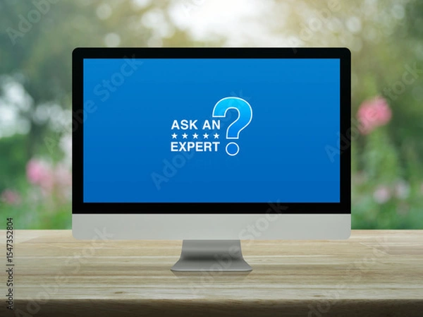 Fototapeta Ask an expert with star and question mark sign icon on desktop modern computer monitor screen on wooden table over blur park, Technology communication online concept