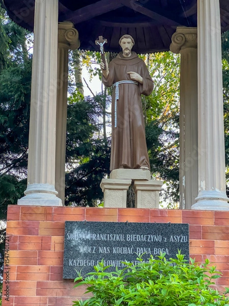 Fototapeta Statue of St. Francis in the garden at the Minor Basilica of Our Lady of Listening Patiently in Rokitno, Poland