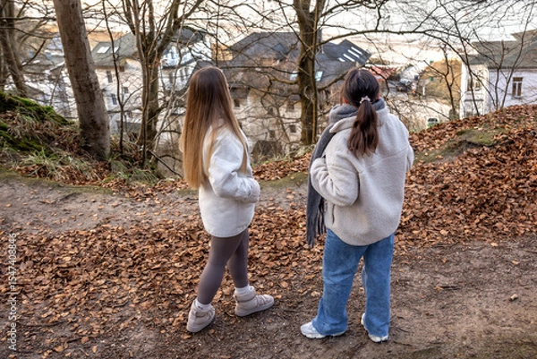 Obraz Two female friends on a walk in the forest. Friends walking through the forest. People in nature.