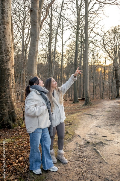 Obraz Two women in the forest. Woman pointing at the scenery. People in nature.