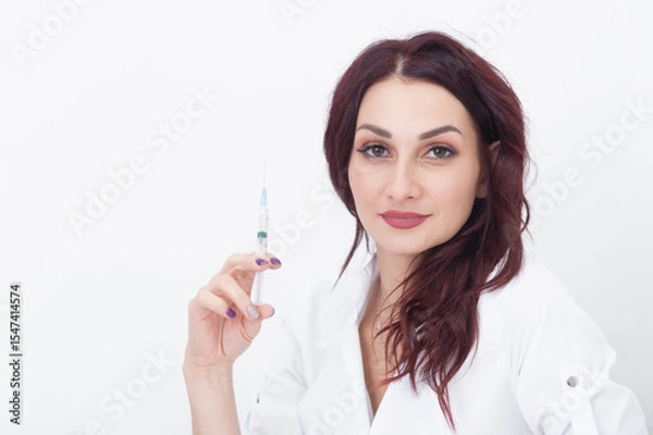 Fototapeta A syringe for injections in the hands of a cosmetologist.