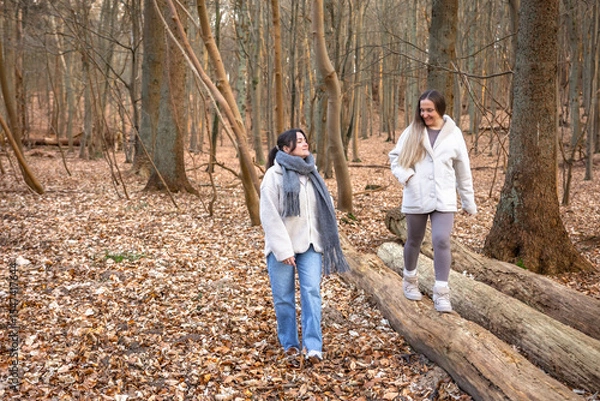 Obraz Two female friends on a walk in the forest. Friends walking through the forest. People in nature.