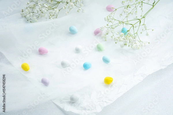 Obraz Colorful candies scattered on delicate white tissue with flowers