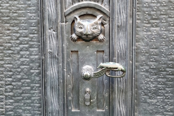 Fototapeta Vintage Cat-Themed Door Knocker on Rustic Metal Surface