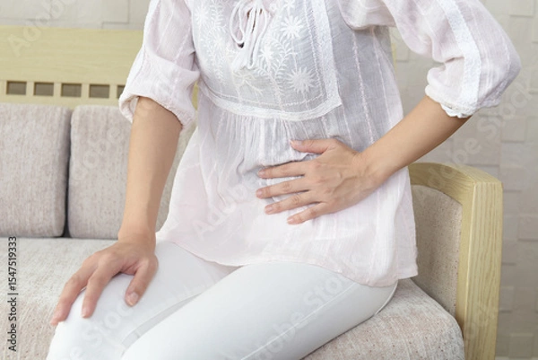 Obraz お腹を押える体調不良の女性