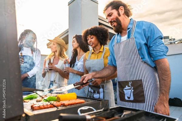 Fototapeta Friends grilling food and drinking beer on rooftop terrace