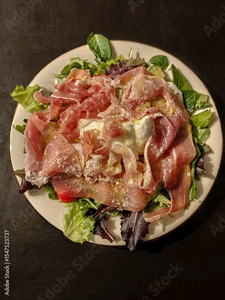 Obraz Italian salad with ham, mozzarella cheese, parmigiano cheese, fresh basil, pepper, and salad leaves