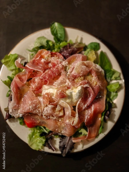 Obraz Italian salad with ham, mozzarella cheese, parmigiano cheese, fresh basil, pepper, and salad leaves