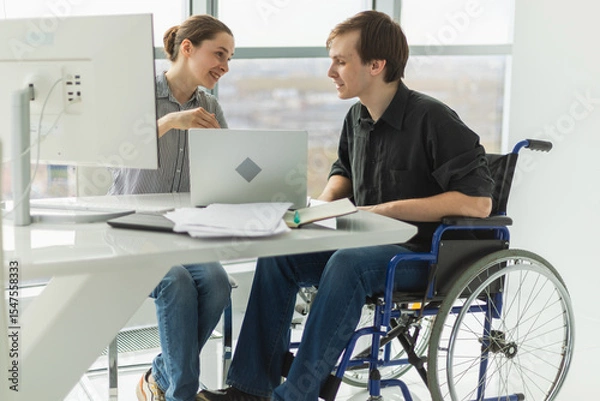 Fototapeta Colleagues business people woman man in chair for people with disability working on office. Startup business group team working together. Corporate professional team discussing project ideas
