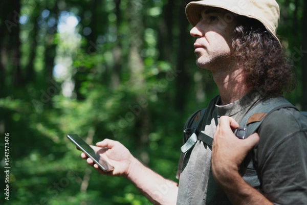 Fototapeta Man Using Smartphone in Forested Area