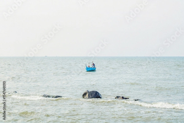Obraz old man on a boat fishing in the sea from a distance