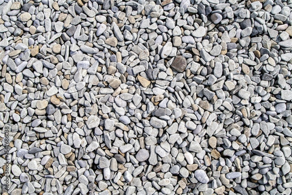 Fototapeta Top view of small round beach pebbles in natural tones creating a textured surface. Concept of simplicity, grounding, and natural balance in minimal design