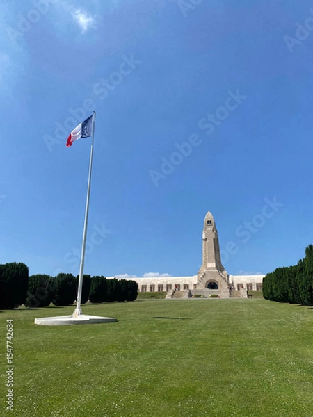 Obraz View of the Douaumont Ossuary from the military cemetery in Verdun, France, under a clear sky, commemorating World War I soldiers