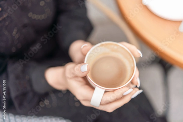 Obraz Coffee Cup Hands Relaxation: Lady holds latte outside cafe table in daytime for relaxation, drink, break.
