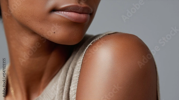 Obraz Smooth dark skin close up showing natural texture on shoulder and lips with soft lighting and neutral background, highlighting healthy and moisturized skin appearance