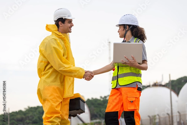 Obraz Environmental Workers Inspecting Industrial Site, Team in Protective Gear Surveying Contaminated Area, Engineer and Environmental Worker Shaking Hands at a Chemical Plant