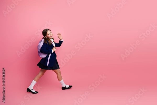 Obraz Happy student in formal school uniform on pink background, waving hand, education and back to school concepts